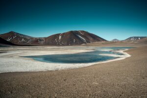 Lagune colorée dans le désert d'Atacama, un paysage spectaculaire de montagnes et de ciel bleu.